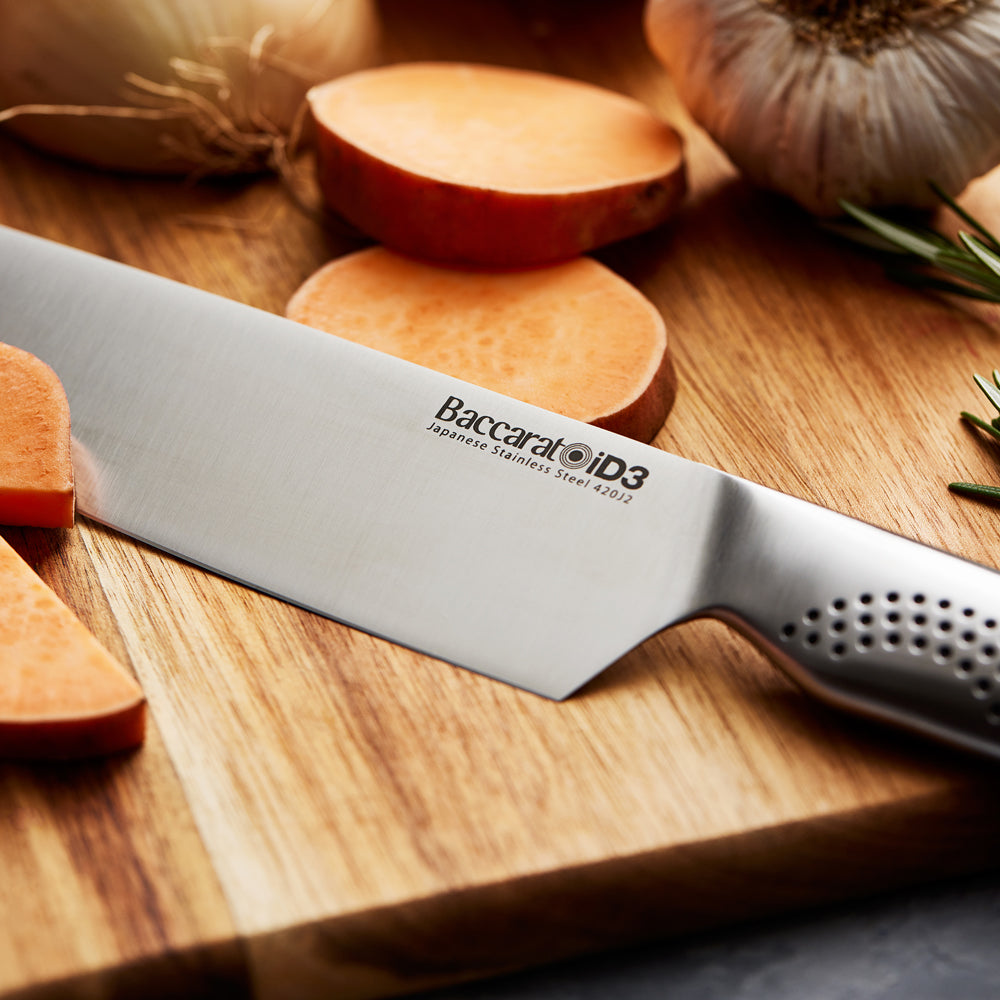 A person slicing vegetables on a wooden board with a chef's knife - Baccarat id3 chefs knife 20cm