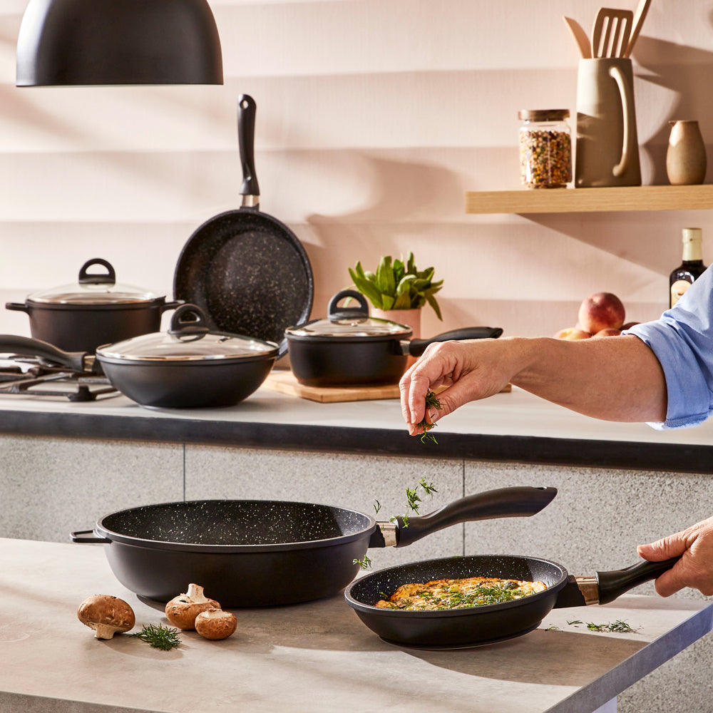 A complete cookware set with non-stick pans and pots featuring sleek black surfaces - Baccarat