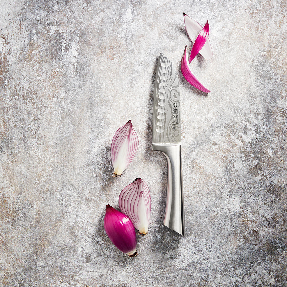 sliced purple shallots on textured surface with shiny blade - Baccarat damashiro santoku knife 14cm