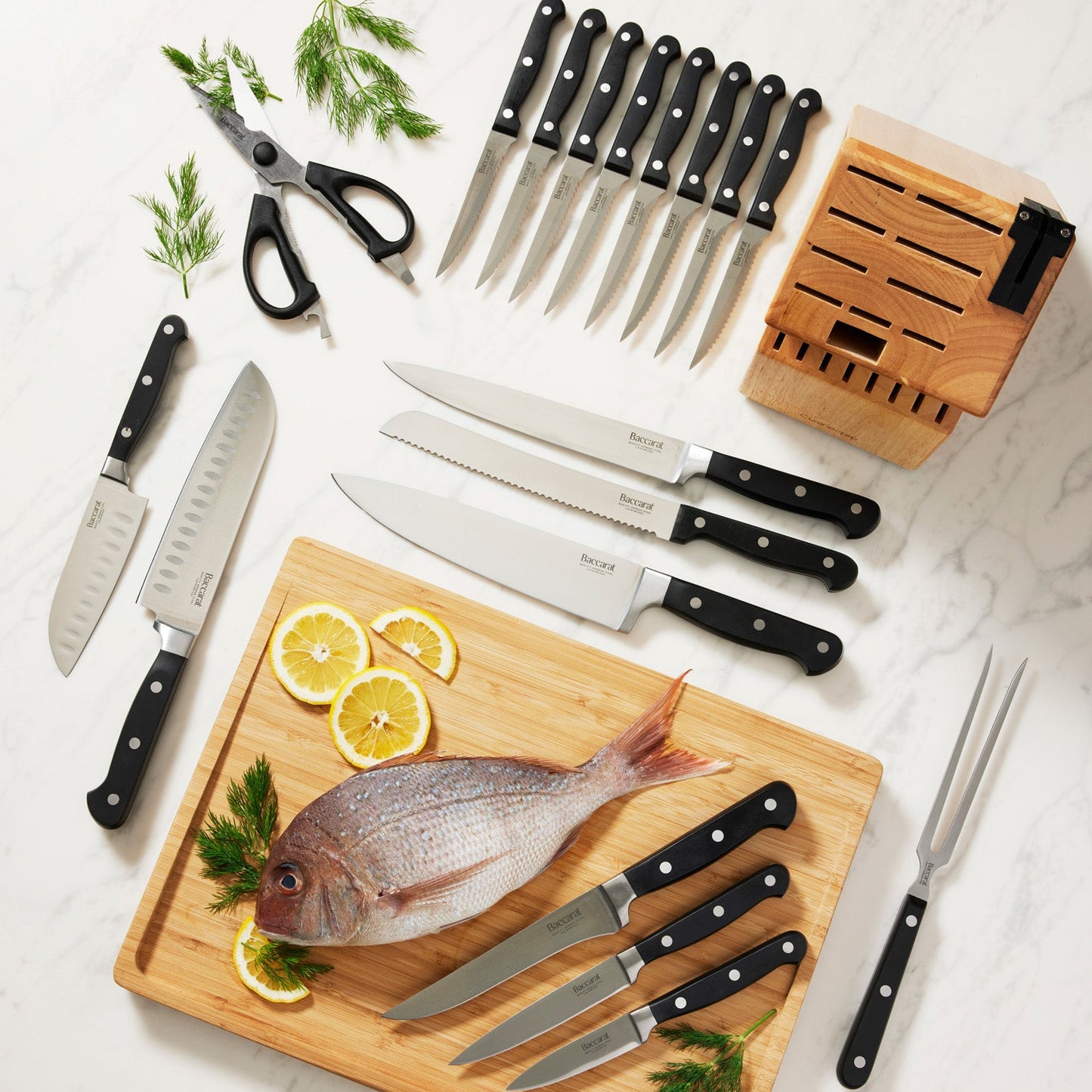 A selection of Sabre kitchen knives and scissors on cutting board with herbs and handles - Baccarat