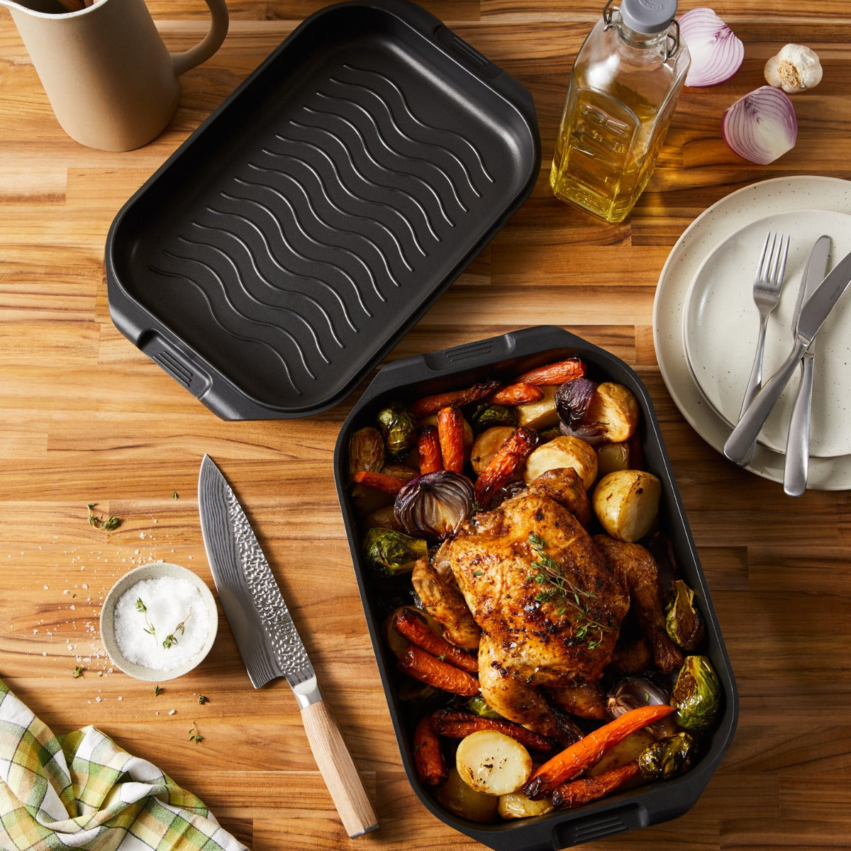 A roasted chicken with vegetables in a nonstick multi pan on a wooden table - Baccarat