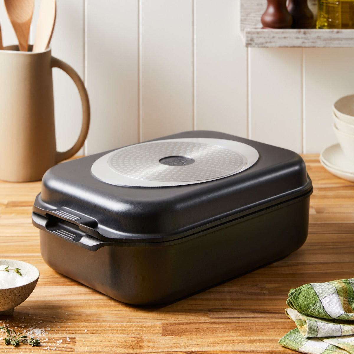 A roasted chicken with vegetables in a nonstick multi pan on a wooden table - Baccarat