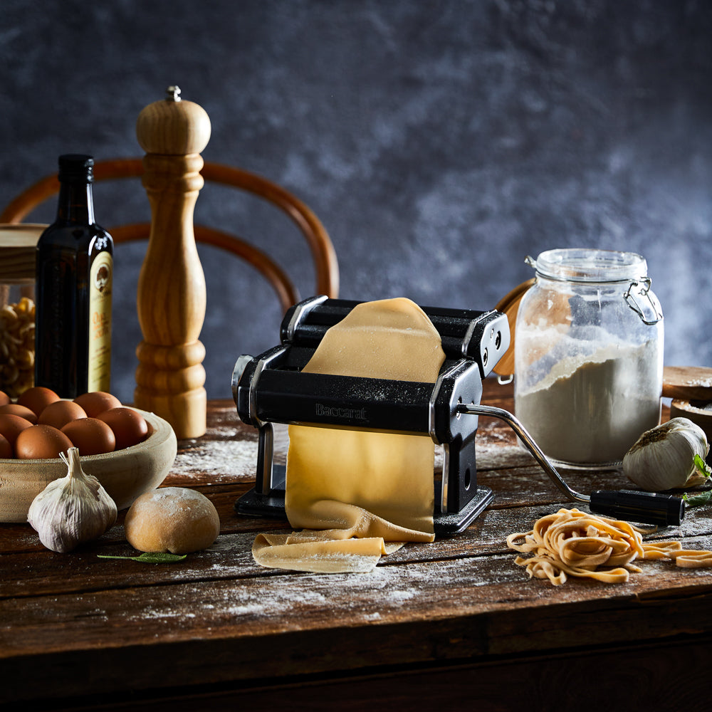 A person creating fresh golden pasta in a cozy kitchen - Baccarat gourmet 150mm pasta machine black
