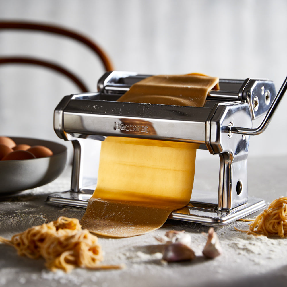 Fresh pasta and flour with a pasta maker on a gray background chrome pasta machine 180mm - Baccarat