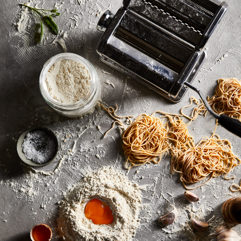 Fresh pasta and flour with a pasta maker on a gray background chrome pasta machine 180mm - Baccarat