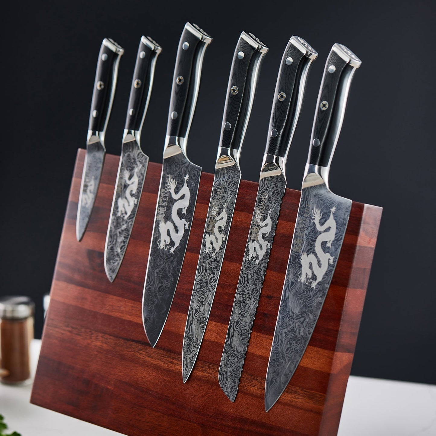 Person chopping ginger and garlic on black cutting board with black Samurai cleaver knife - Baccarat