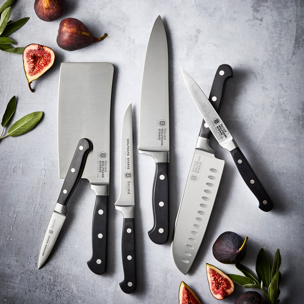 15cm stainless steel chef's knife with sleek black handle beside its box - Baccarat wolfgang starke