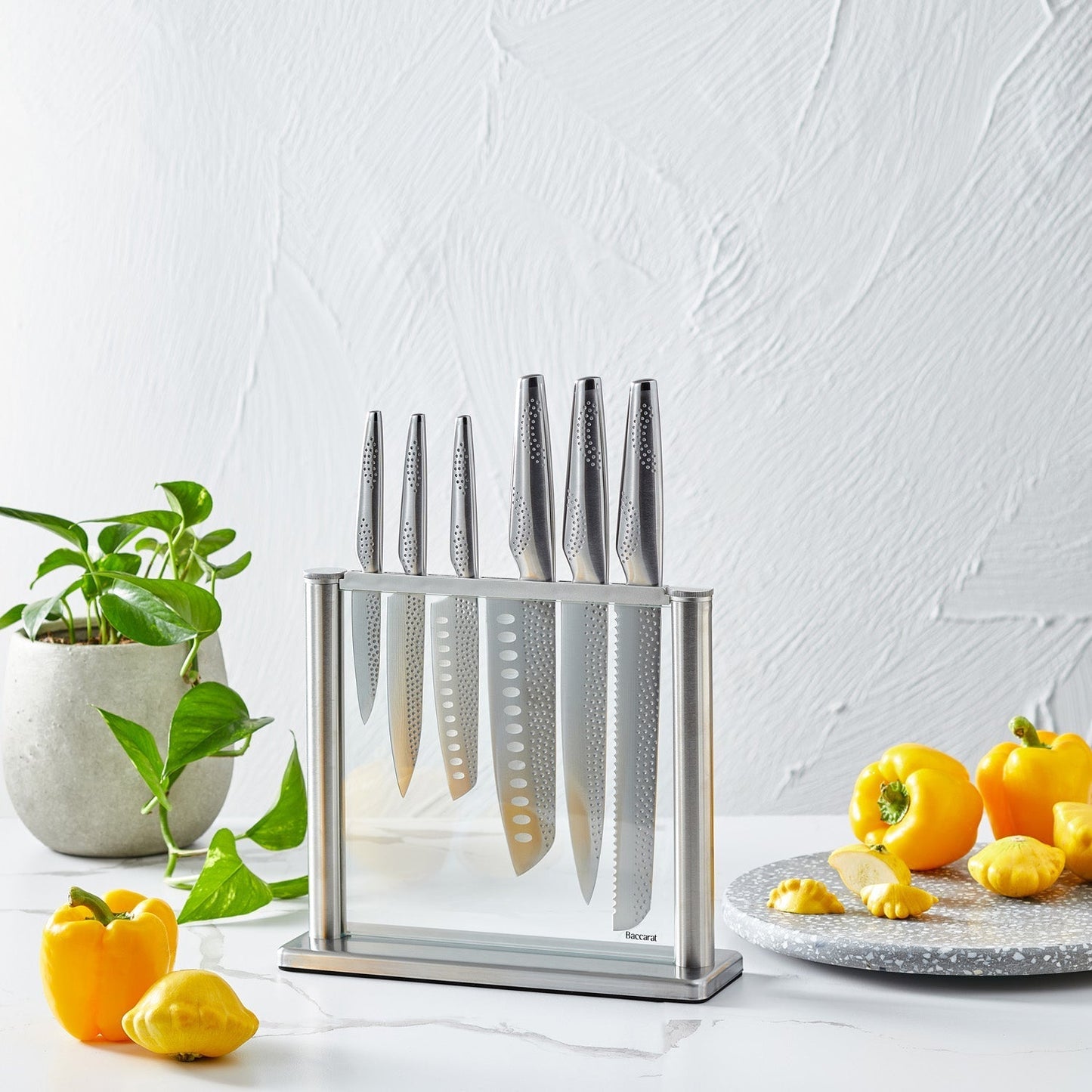 A polished knife block set with sharp blades and sleek design next to fresh vegetables - Baccarat