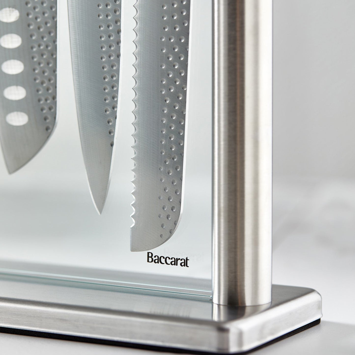 A polished knife block set with sharp blades and sleek design next to fresh vegetables - Baccarat