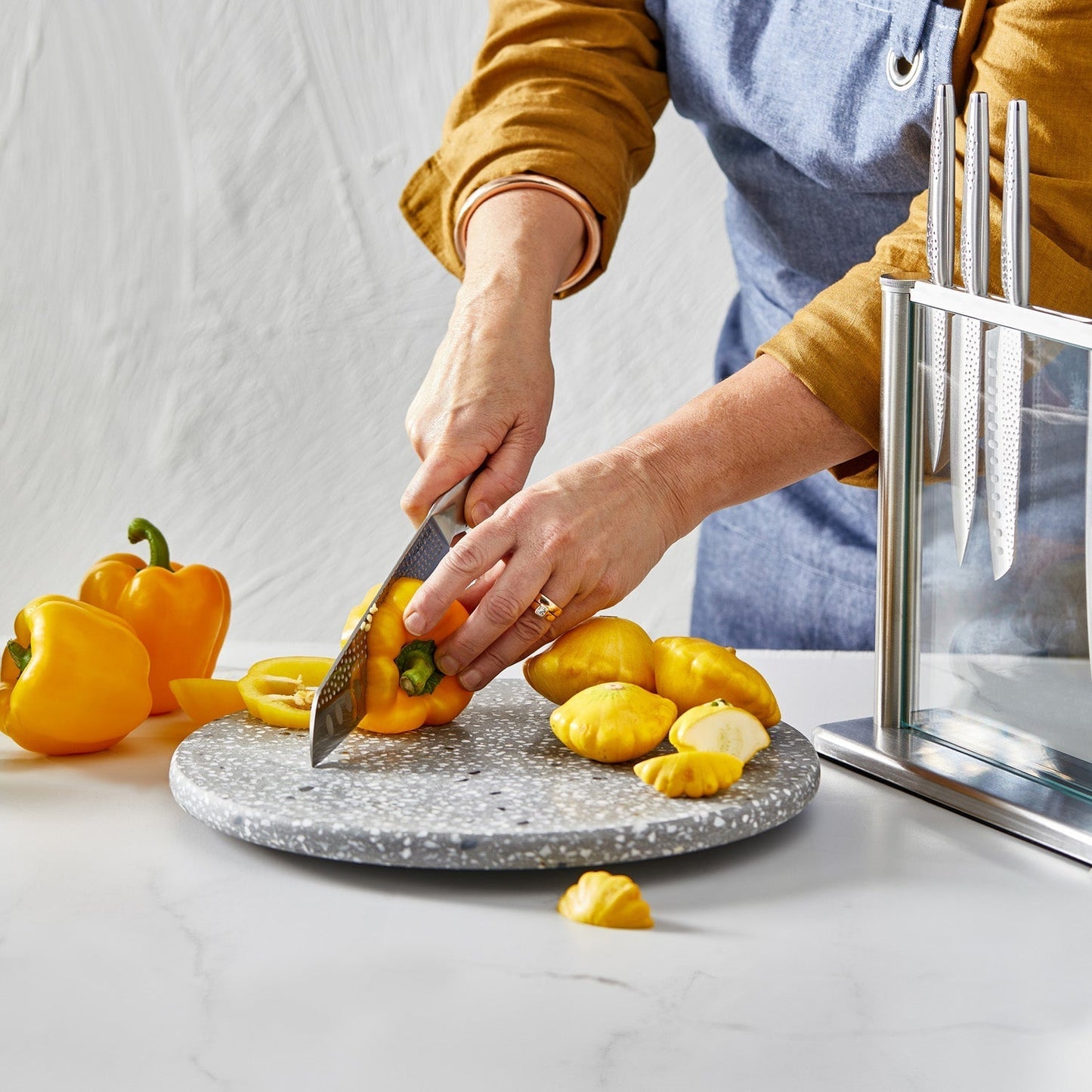A polished knife block set with sharp blades and sleek design next to fresh vegetables - Baccarat