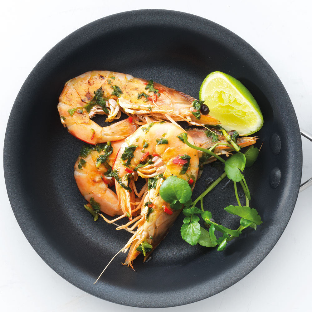 Cooked shrimp with herbs and a lime wedge in a hard anodised frypan 16cm - Baccarat