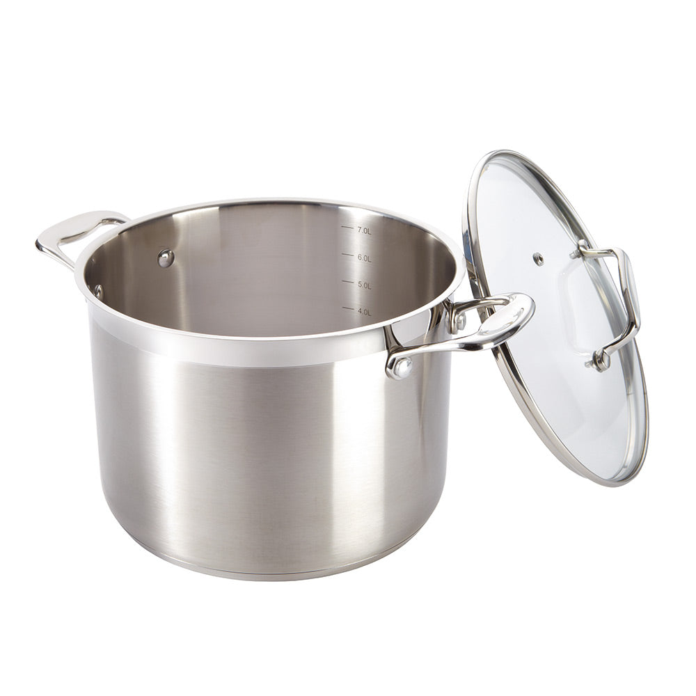 A silver stockpot with lid surrounded by kitchen utensils on a gray background - Baccarat