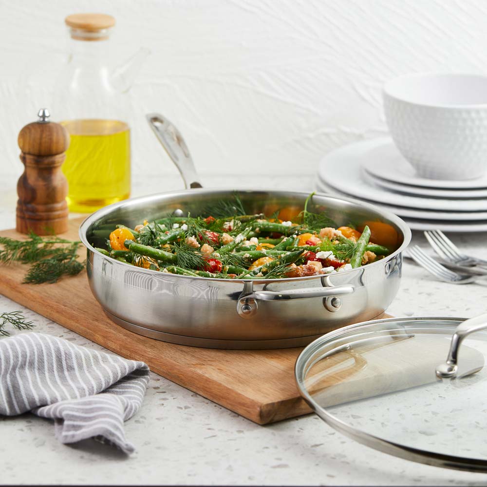 A sleek sauté pan with a glass lid that gleams in the light - silver cookware - Baccarat iconix