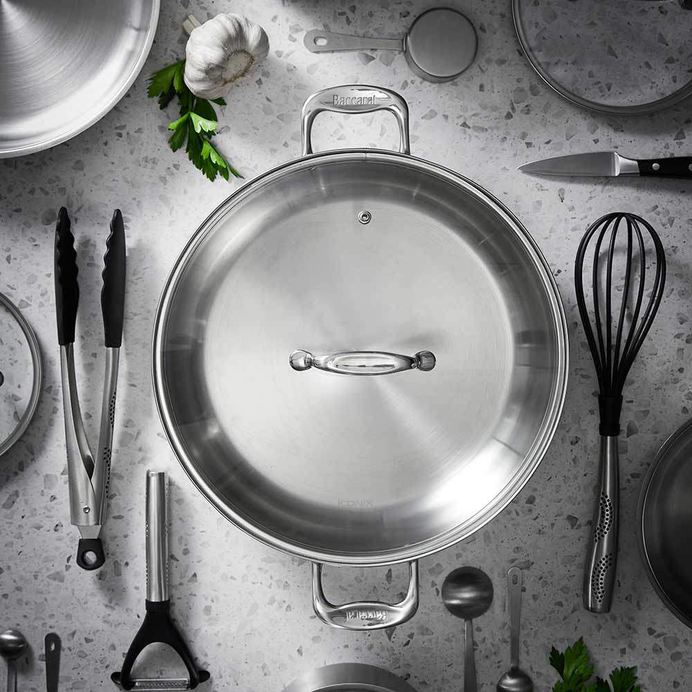 Overhead view of a stainless steel chef pan with lid and kitchen tools - Baccarat Iconix