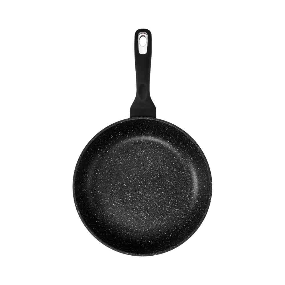 Person cooking vegetables in a granite frying pan 28cm with a pepper grinder nearby - Baccarat