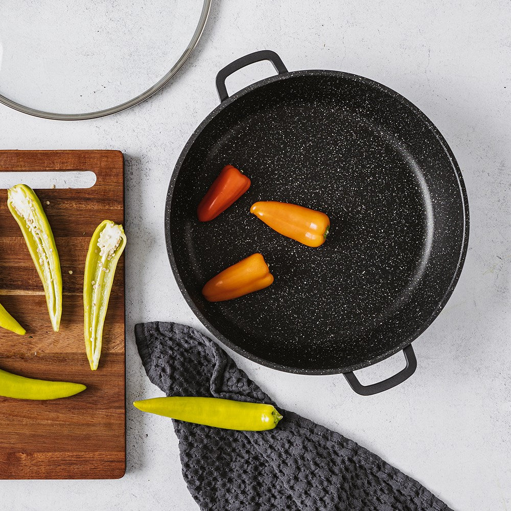 Overhead view of a saute pan filled with fresh vegetables and sliced peppers - Baccarat