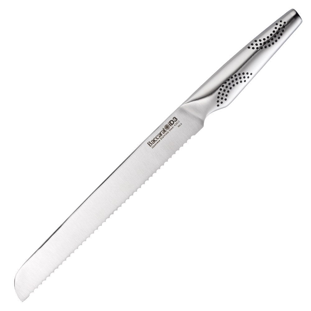 A sleek serrated bread knife is positioned on a wooden cutting board next to fresh bread - Baccarat