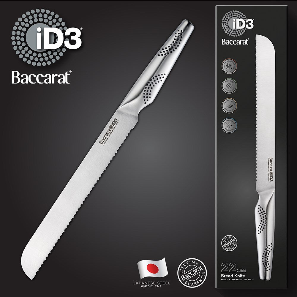 A sleek serrated bread knife is positioned on a wooden cutting board next to fresh bread - Baccarat
