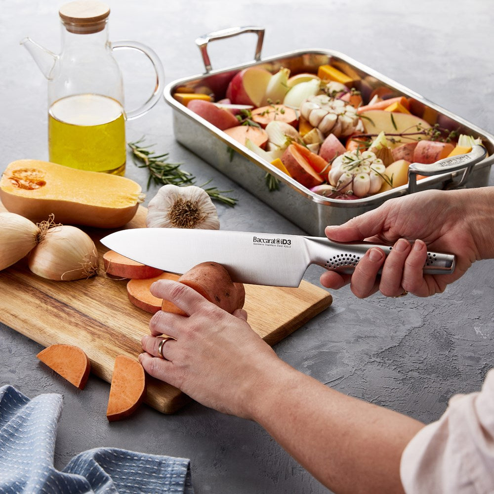 A person slicing vegetables on a wooden board with a chef's knife - Baccarat id3 chefs knife 20cm