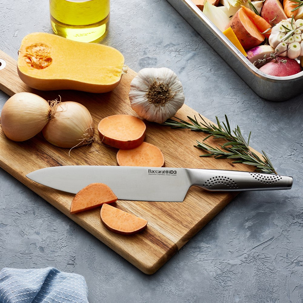 A person slicing vegetables on a wooden board with a chef's knife - Baccarat id3 chefs knife 20cm