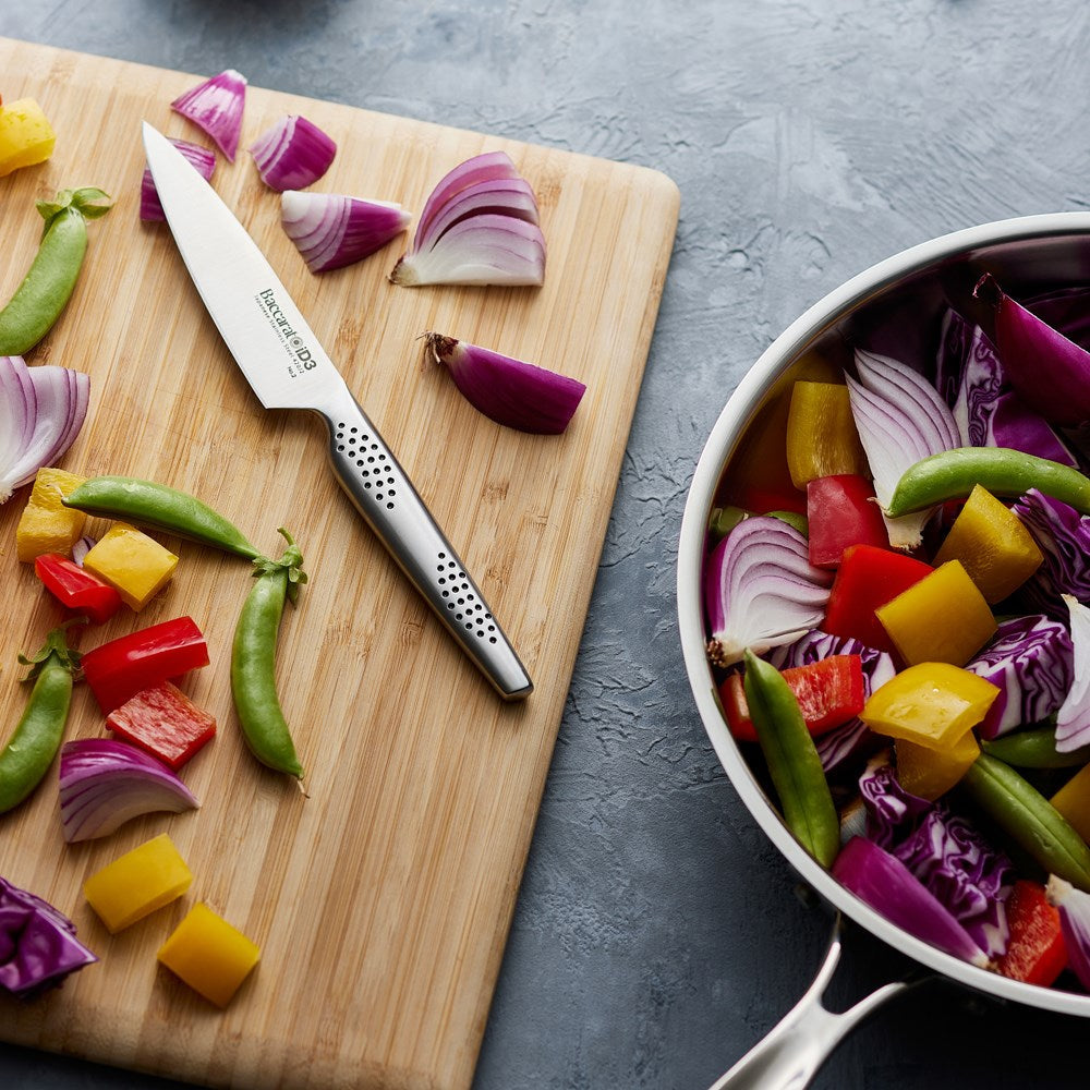 Chopped vegetables on a wooden board with fried veggies in a pan - Baccarat id3 11cm Utility Knife