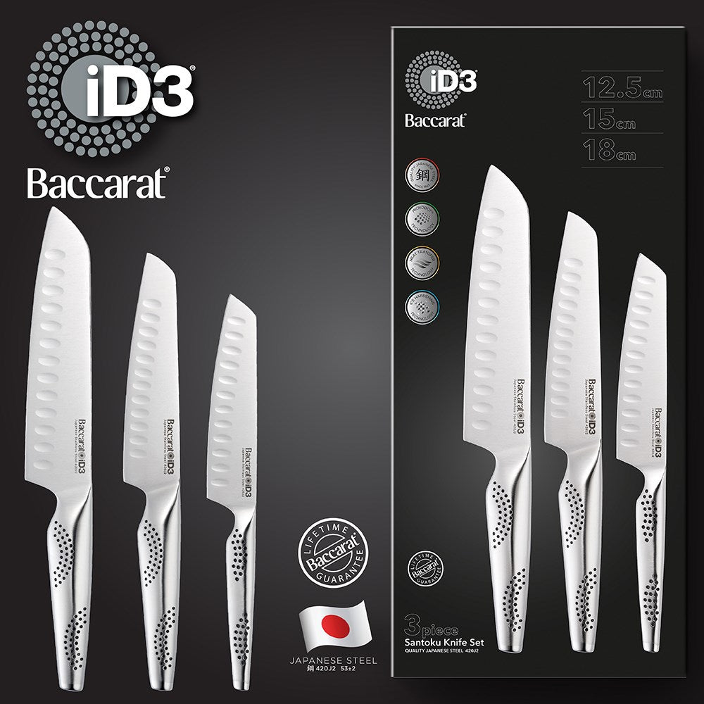 Three santoku knives resting on a wooden cutting board with fresh herbs and vegetables - Baccarat