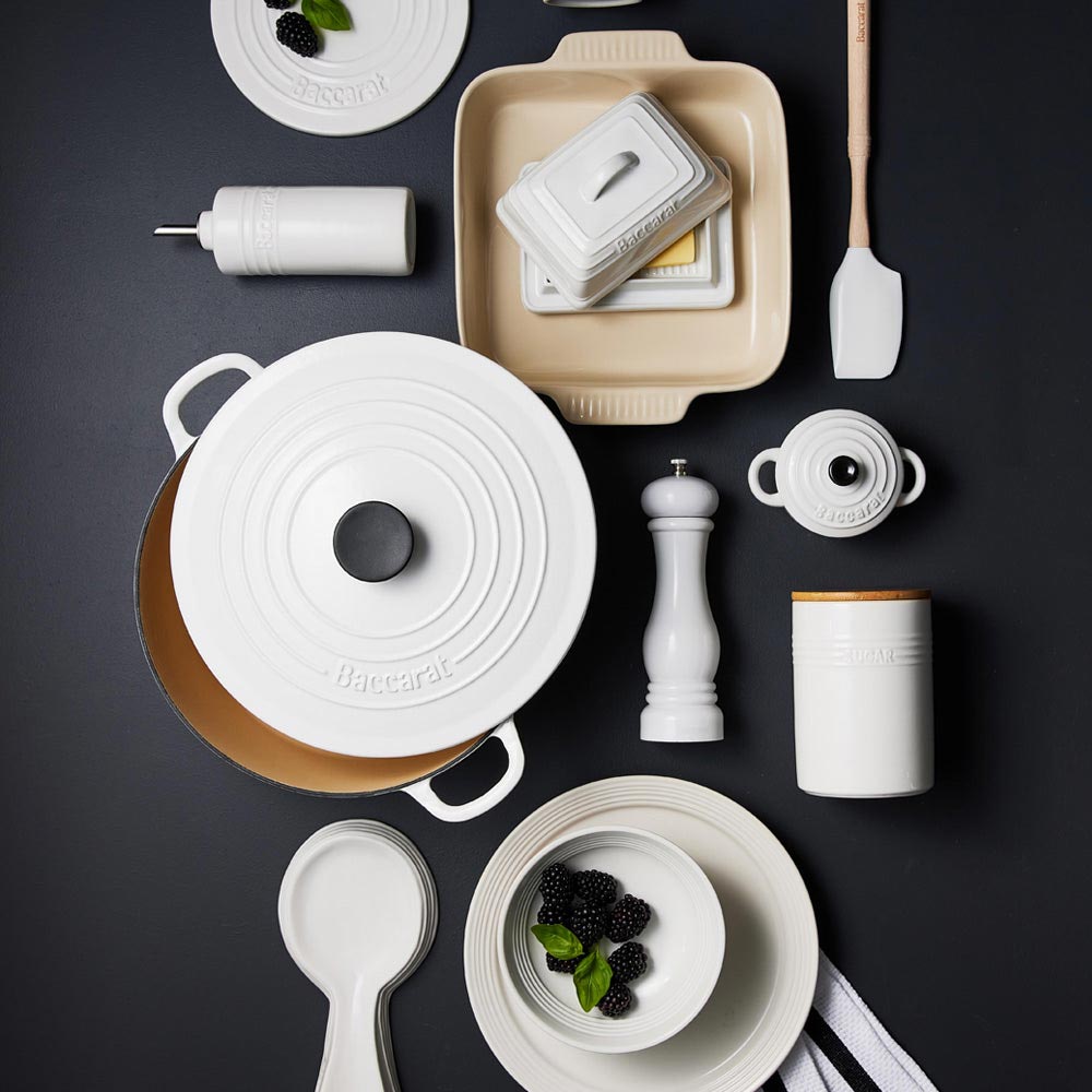 Black cast iron round French oven on stovetop with plates and greenery - Baccarat Le Connoisseur
