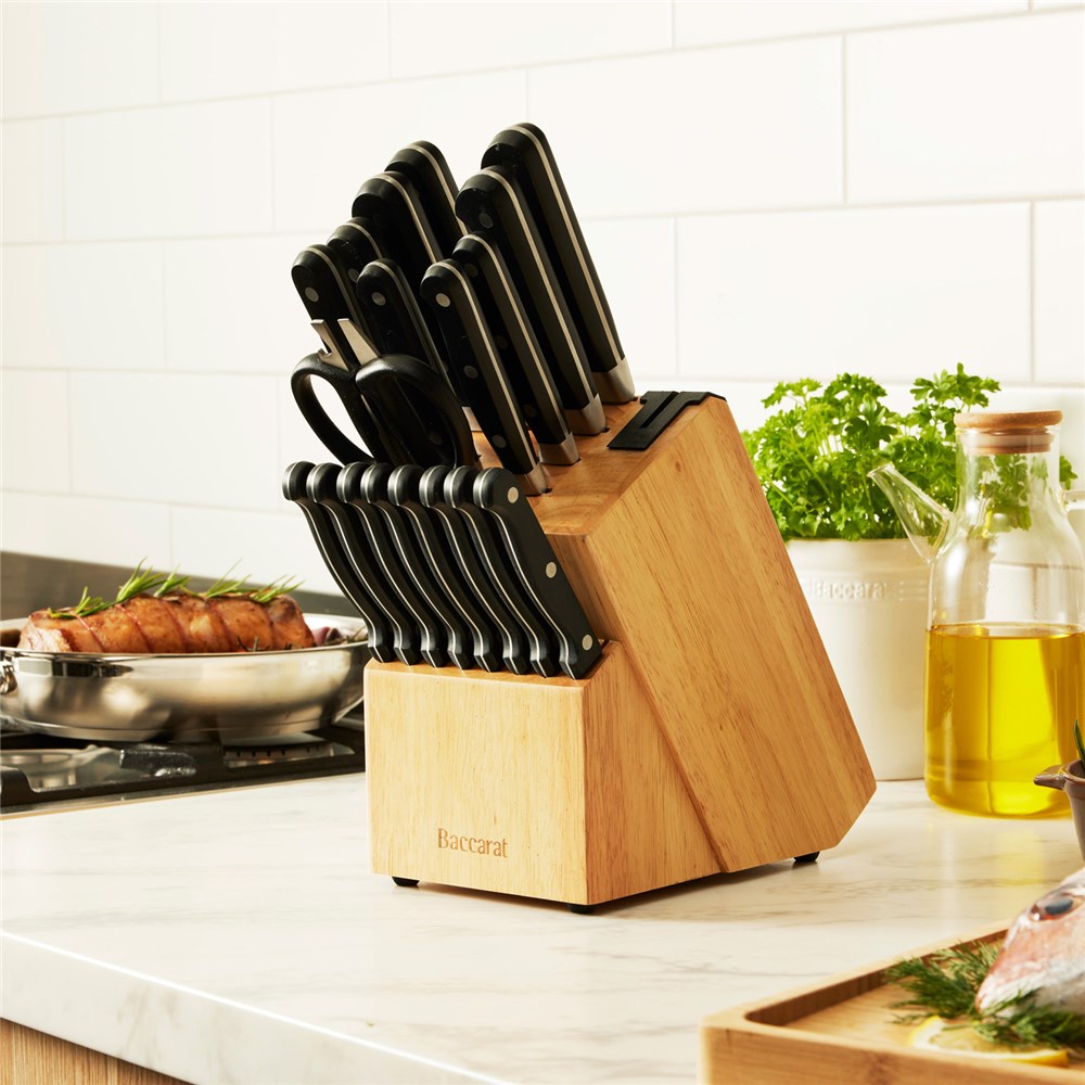 A selection of Sabre kitchen knives and scissors on cutting board with herbs and handles - Baccarat