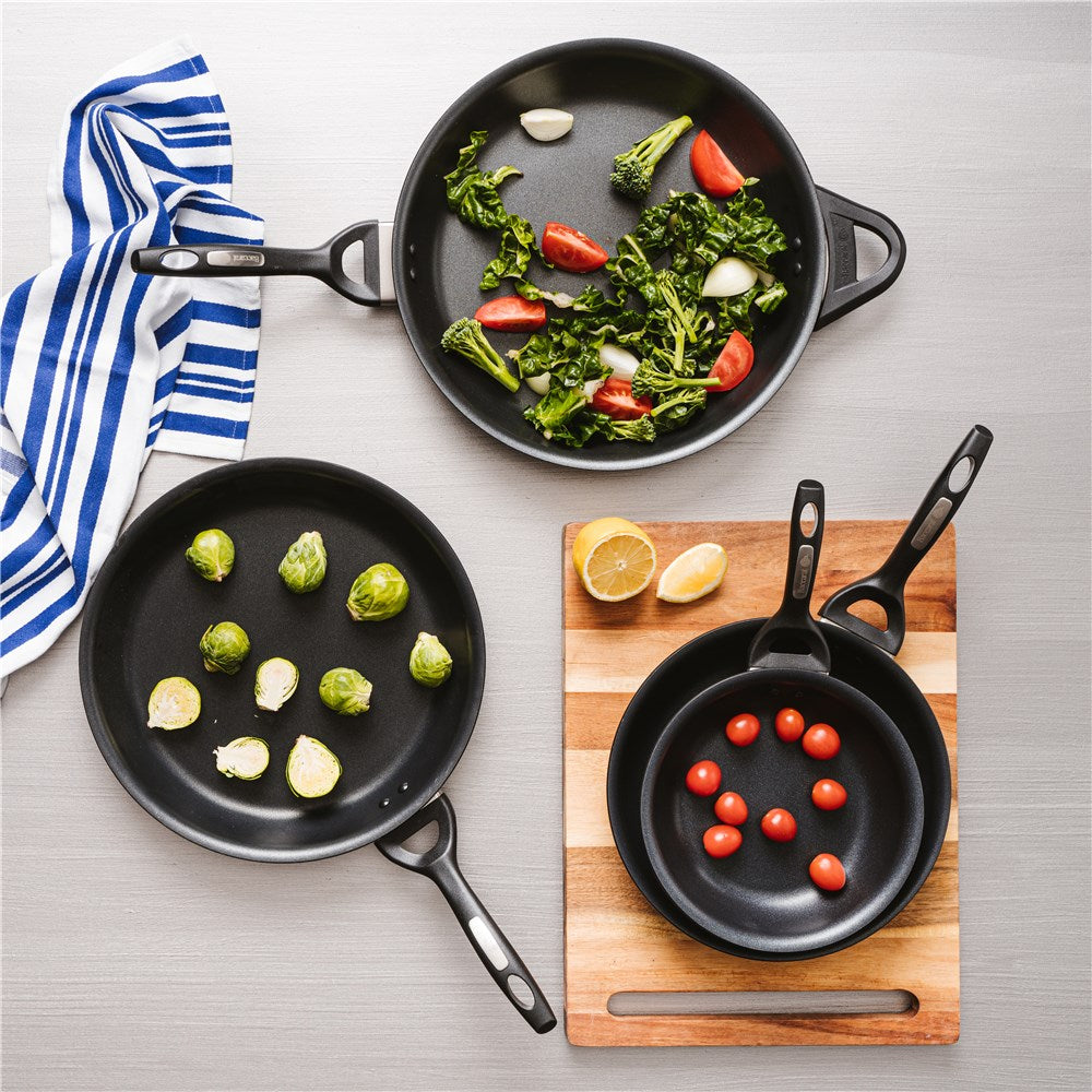 A frying pan filled with a cooked egg greens and potatoes - black non-stick hard anodised - Baccarat
