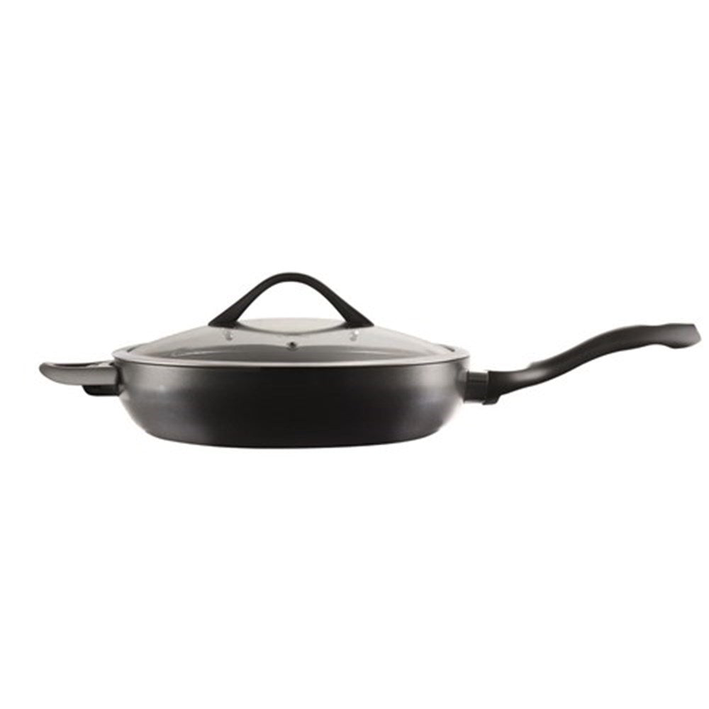 A sauté pan with chopped onions and green vegetables on a striped cloth - Baccarat