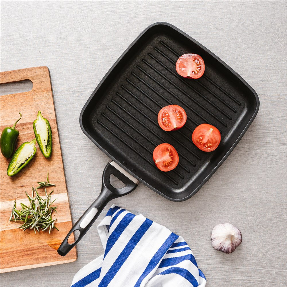 Sliced tomatoes and jalapeños on a cutting board with black griddle - Baccarat id3 cs hard anodised