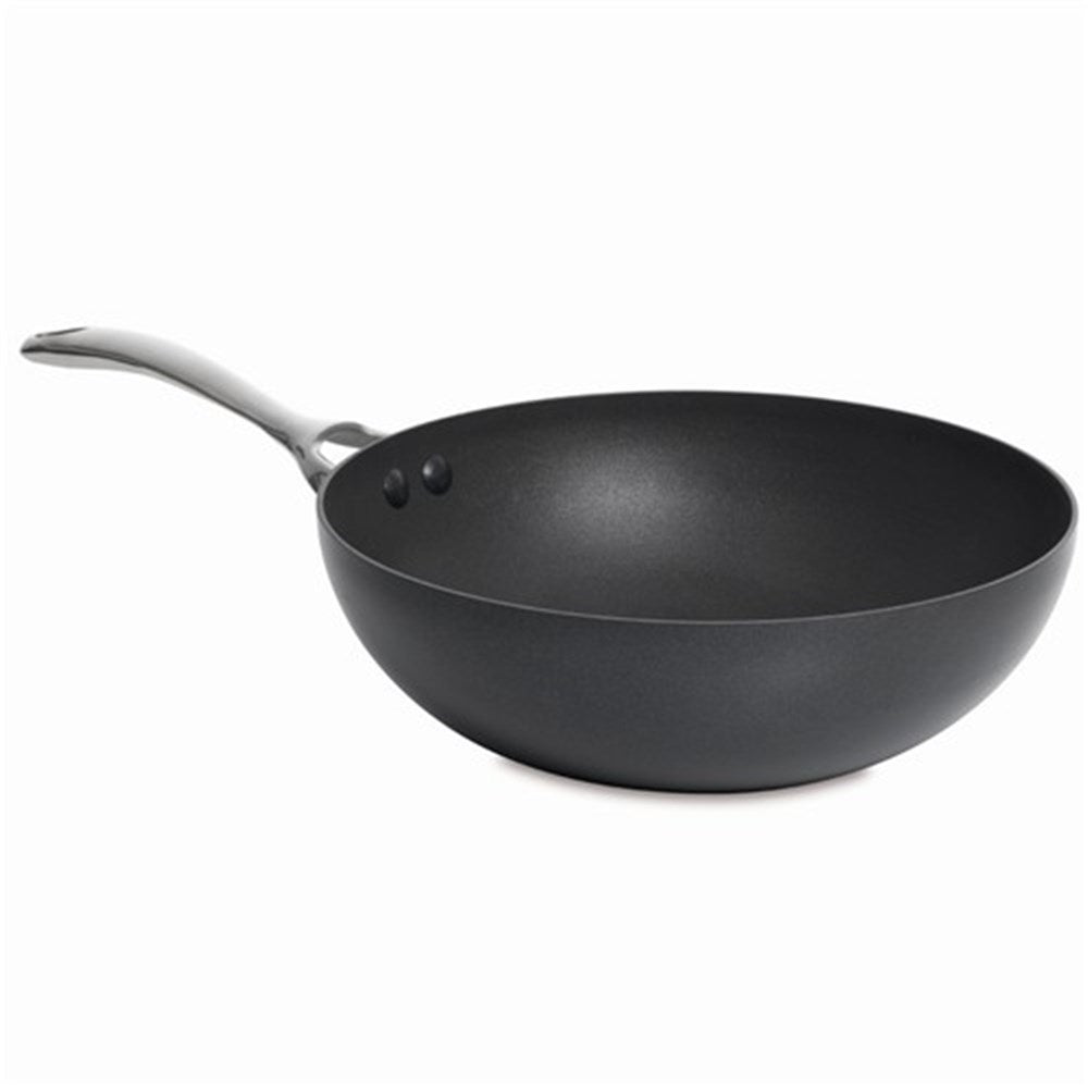 A stir fry pan filled with diced vegetables on a wooden board next to a grey cloth - Baccarat