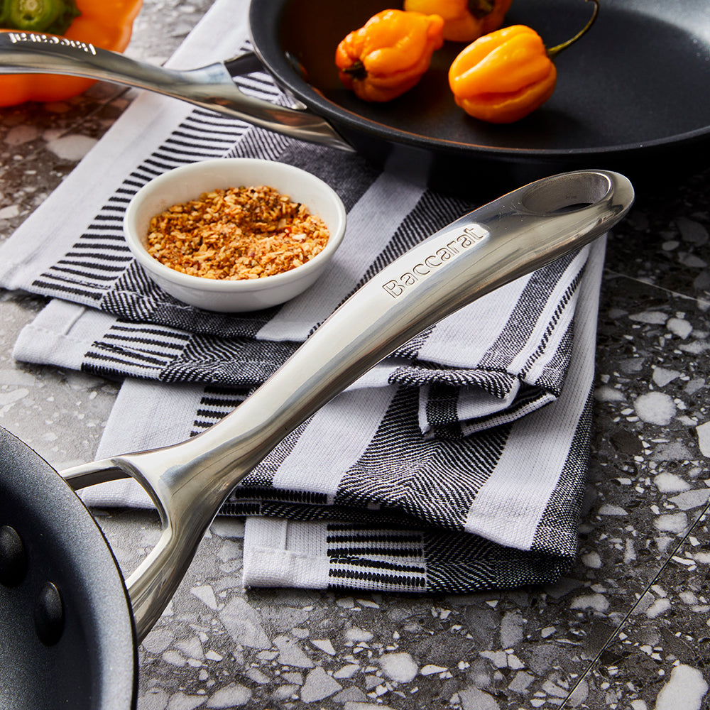 Two frying pans with bell pepper slices on a gray surface - Baccarat id3 hard anodised frypan