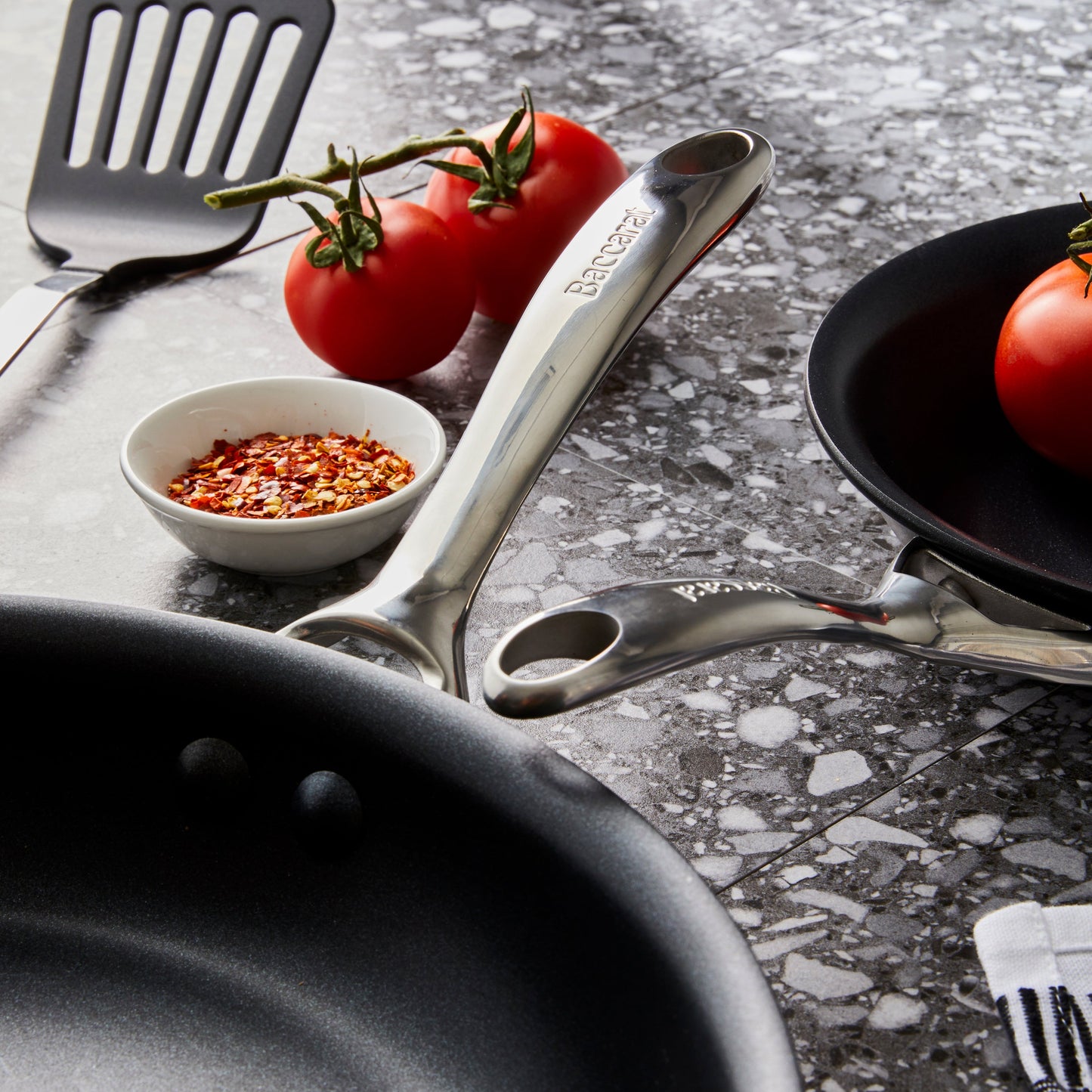 Two hard anodised non stick frying pans with vibrant tomatoes and peppers - Baccarat