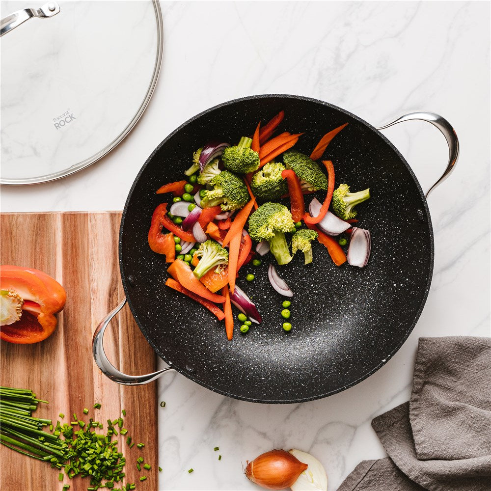 A vibrant vegetable stir fry in a black wok on a marble countertop - 32cm Pan with Lid- Baccarat