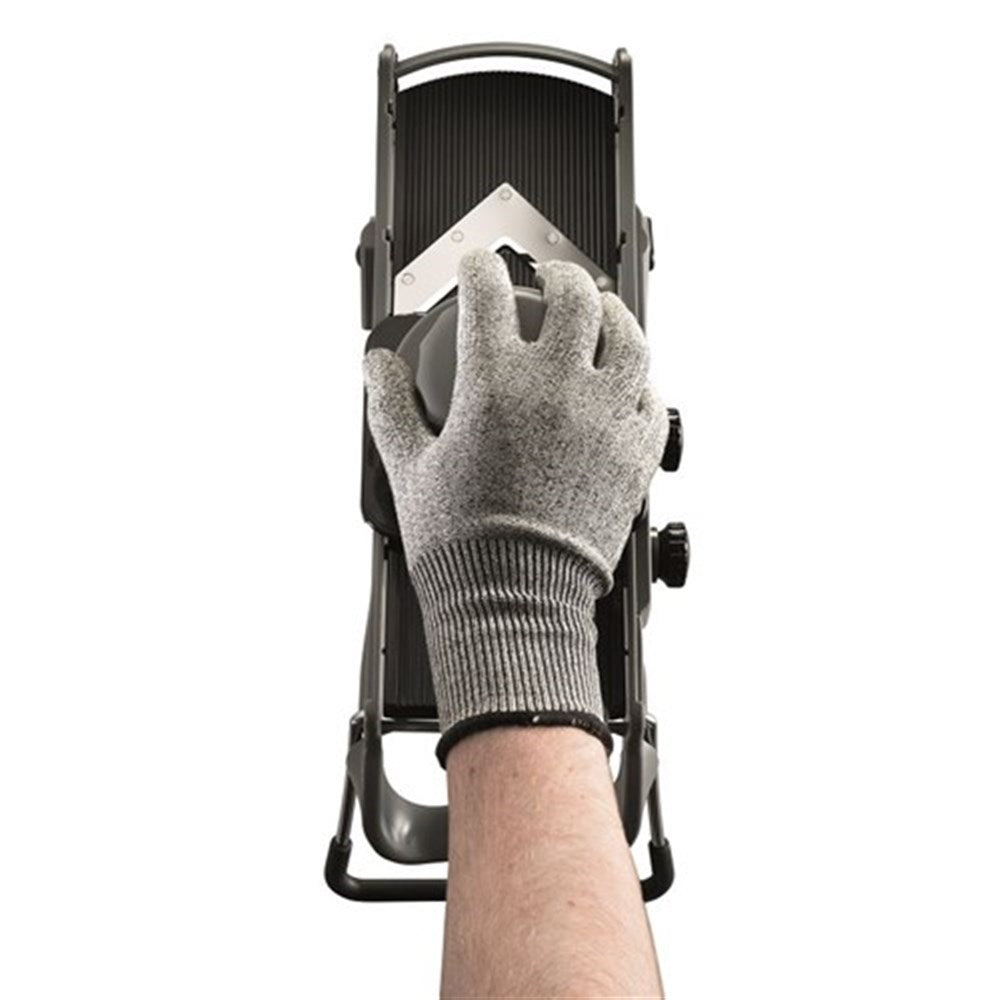 Grating cheese with a protective glove on a stainless steel grater with a sleek design - Baccarat