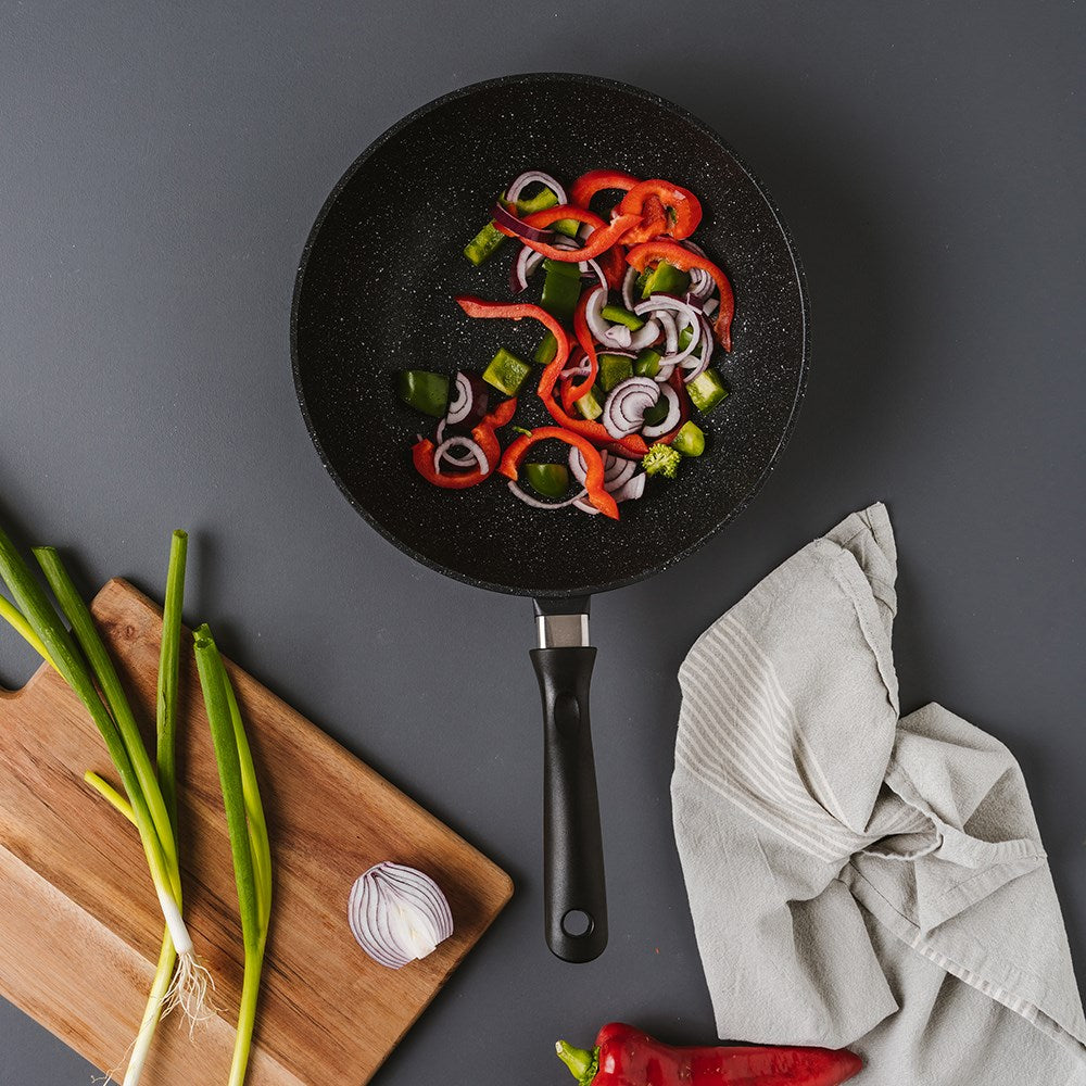 Sliced red peppers and onions in a Baccarat Stone Frypan 28cm with cooking utensils