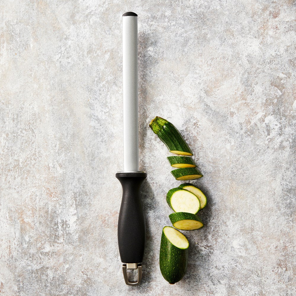 Sharp stainless steel knife resting on a wooden cutting board with fresh herbs - Baccarat Damashiro