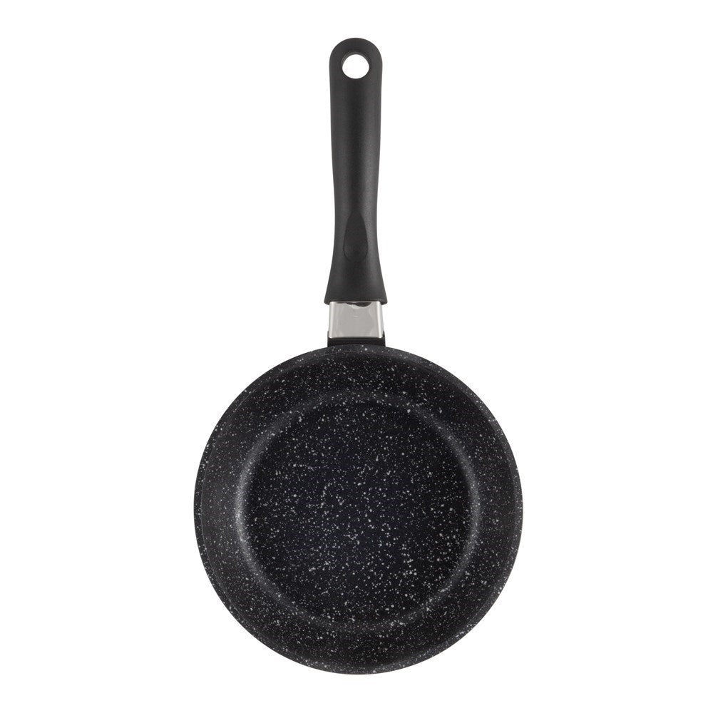 A hand holds a frying pan with grilled salmon and lemon slices stone grey - Baccarat