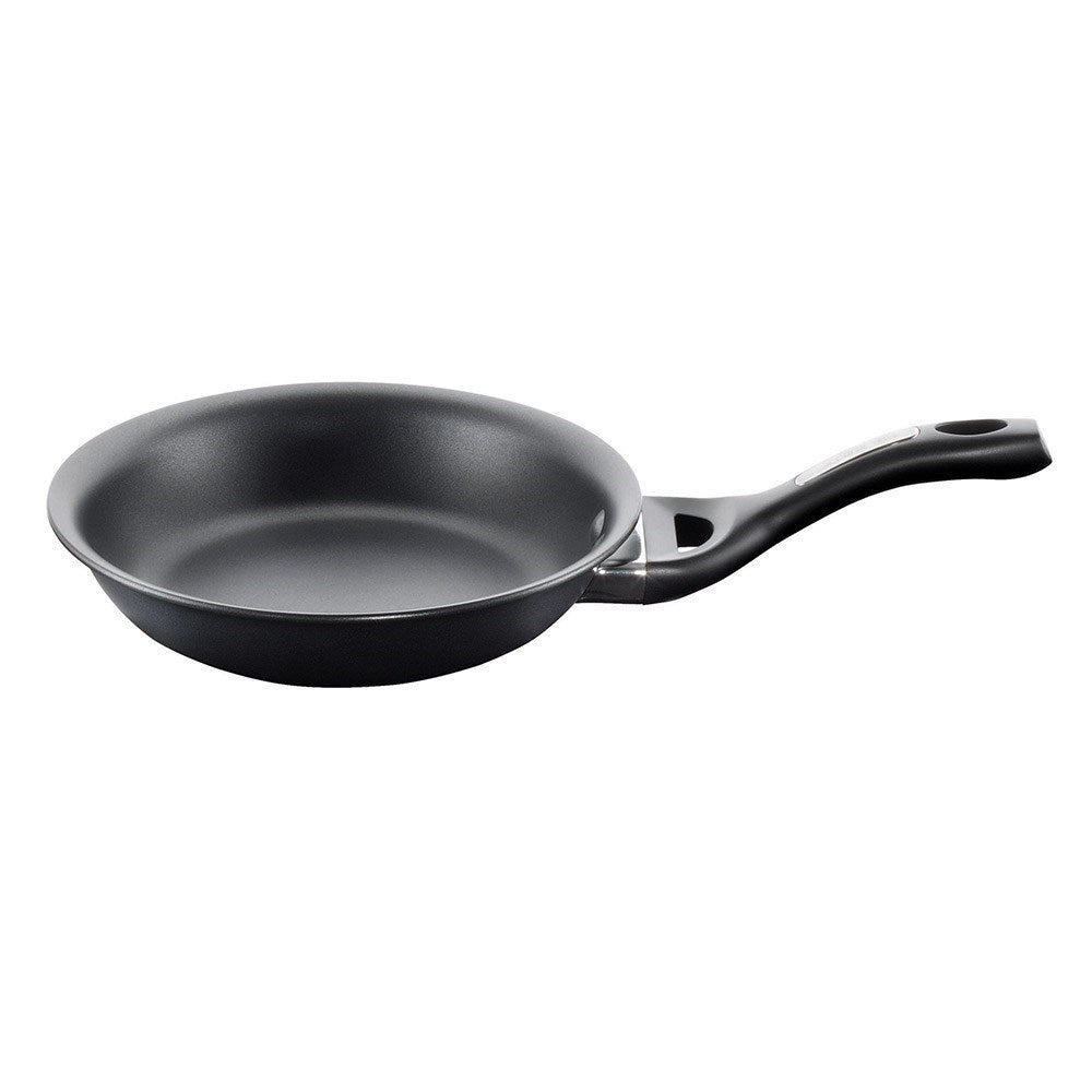 A black frying pan with vegetables and a fried egg hard anodised cookware 22cm fry pan - Baccarat