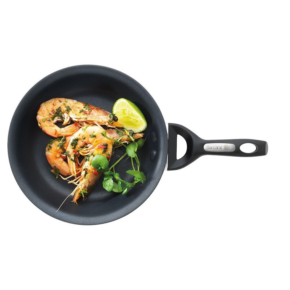 A black frying pan with vegetables and a fried egg hard anodised cookware 22cm fry pan - Baccarat