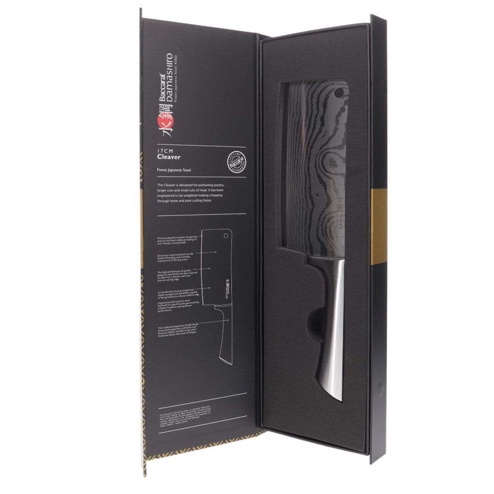A Baccarat Damashiro cleaver with a sleek finish on a rustic surface surrounded by fresh ingredients