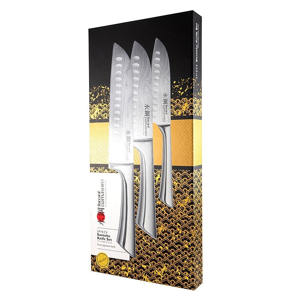 Three sleek santoku knives with textured blades on a gold and black background - Baccarat Damashiro