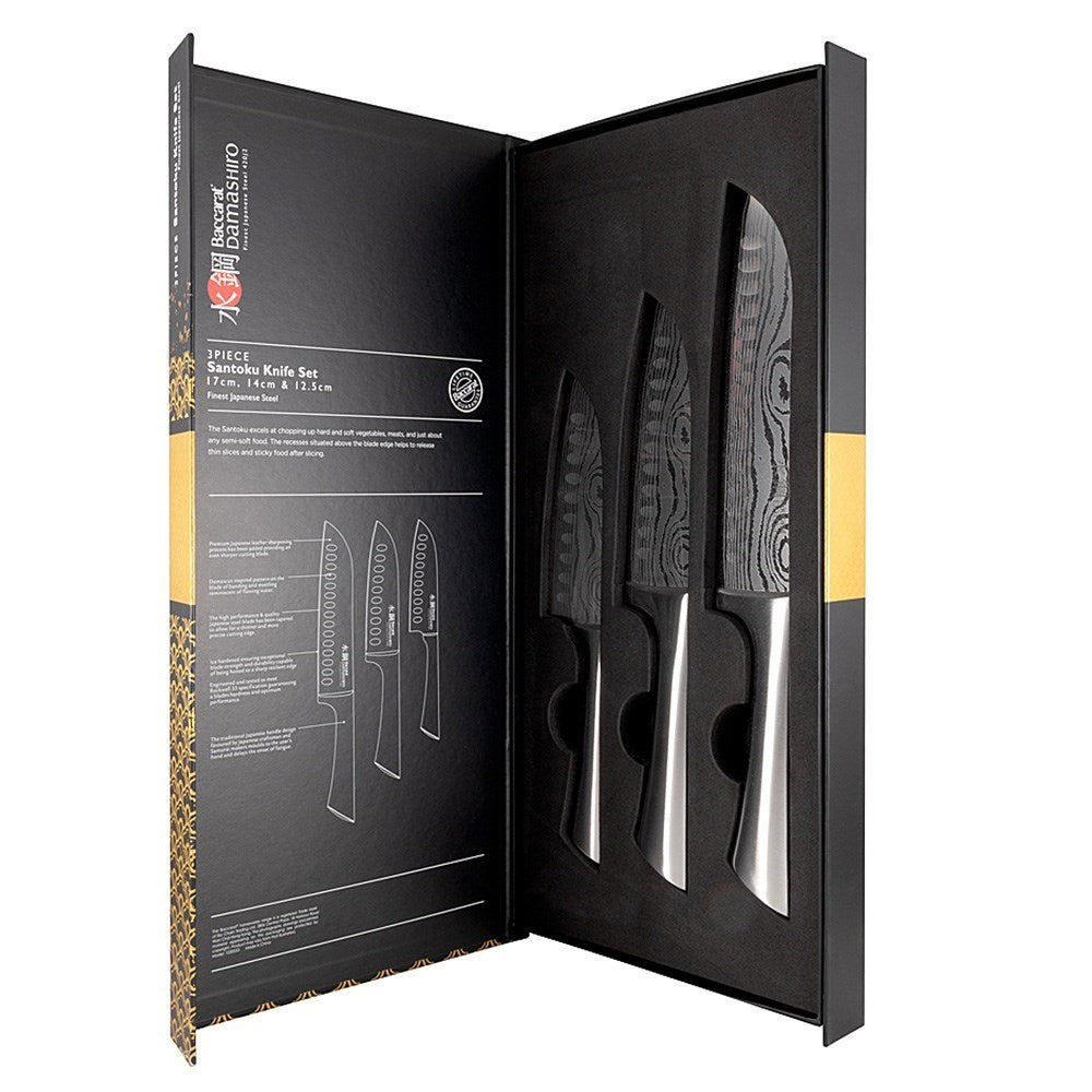 Three sleek santoku knives with textured blades on a gold and black background - Baccarat Damashiro