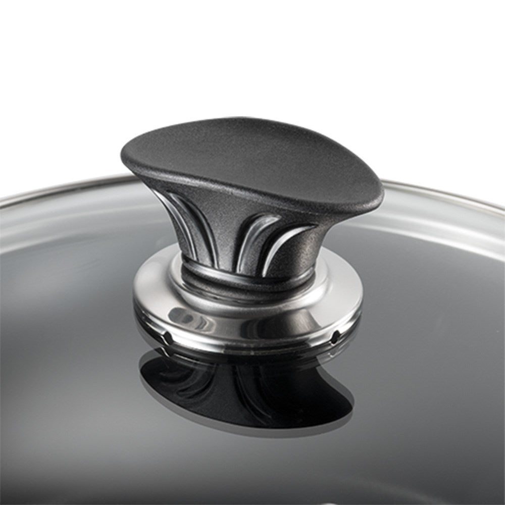 Close-up of a transparent glass lid with a sleek black handle - Baccarat universal glass cookware