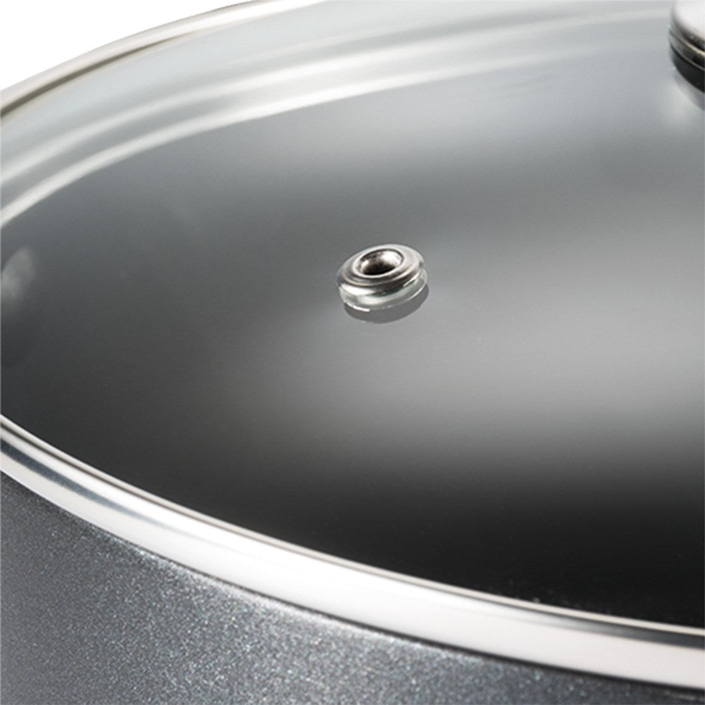 Close-up of a transparent glass lid with a sleek black handle - Baccarat universal glass cookware