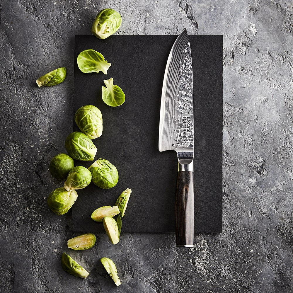 Sliced red peppers on a stone board with a sharp knife - Baccarat damashiro emperor chefs knife 20cm