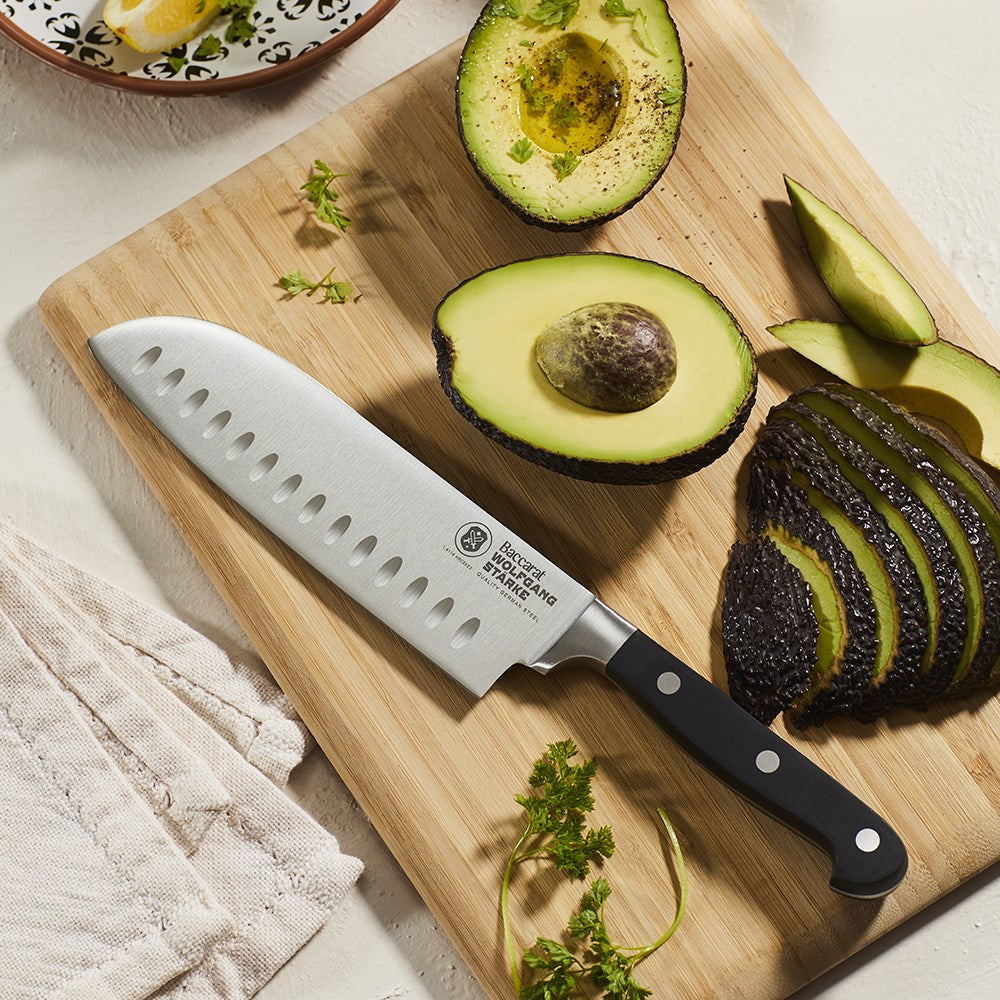 15cm stainless steel chef's knife with sleek black handle beside its box - Baccarat wolfgang starke