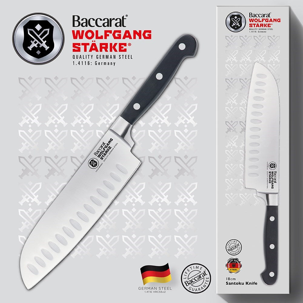 15cm stainless steel chef's knife with sleek black handle beside its box - Baccarat wolfgang starke