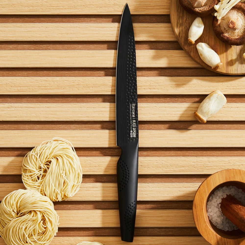 A sharp chef's knife with a black blade and textured handle perfect for precision cutting - Baccarat